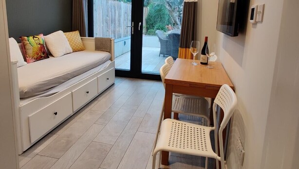 Une pièce de taille modeste comprenant un lit, une table à manger et un téléviseur.