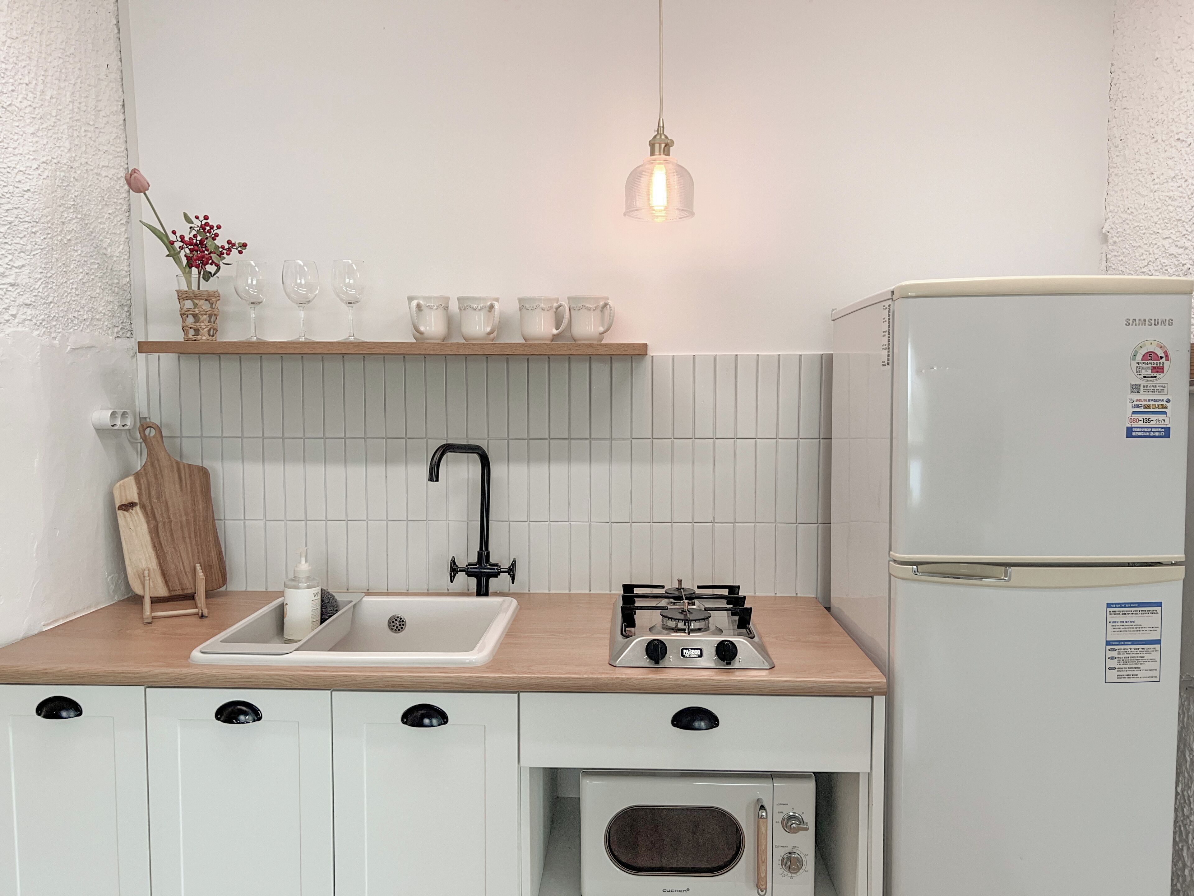 A modern kitchen with a sink, stove, oven, and a refrigerator.