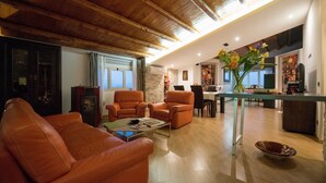 Una sala de estar moderna con sofás de cuero, una zona de comedor y una cocina.