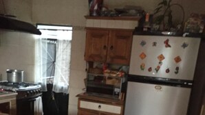 A compact kitchen with a tiled backsplash, wooden cabinets, a refrigerator, and a stove. - Nice house in bugambilias extension (Jiutepec)