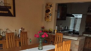 A dining area with a wooden table, chairs, and a vase with flowers. - Nice house in bugambilias extension (Jiutepec)