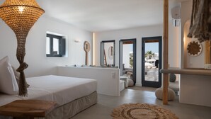 Une chambre à coucher moderne avec un grand lit, un luminaire suspendu et une vue sur l’extérieur.