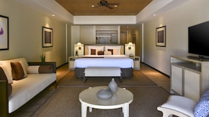 Una habitación de hotel moderna con una cama, un sofá, un televisor y una pequeña mesa.