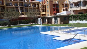A swimming pool with a metal ladder and a small deck area. - Fantastic oceanfront apartment (Torrox Costa)