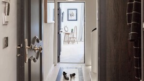A hallway leading to a room with a door, a coat rack, and a small table with a chair. - Maison du Collectionneur (Aix-en-Provence)