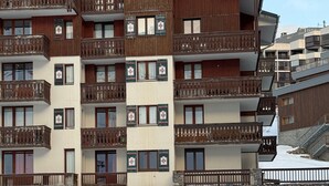 Un hotel a più piani con balconi in legno e facciata in pietra.