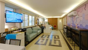 A modern hotel lobby with a reception desk, seating area, and a bar. - 85 Asia Hotel (Kaohsiung)