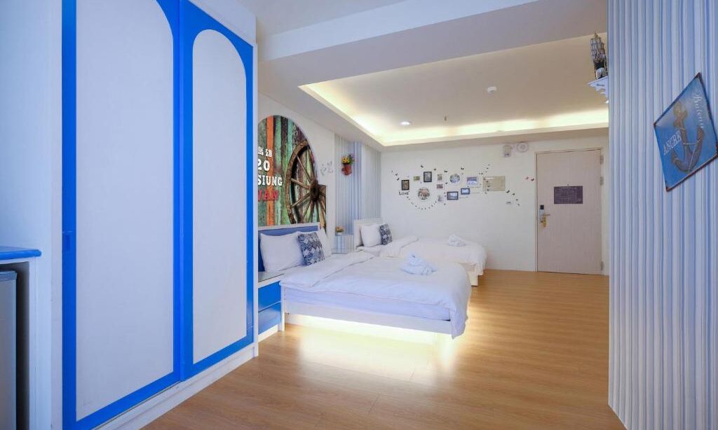 Een slaapkamer met een groot bed, een wandklok en een deur met een bordje.