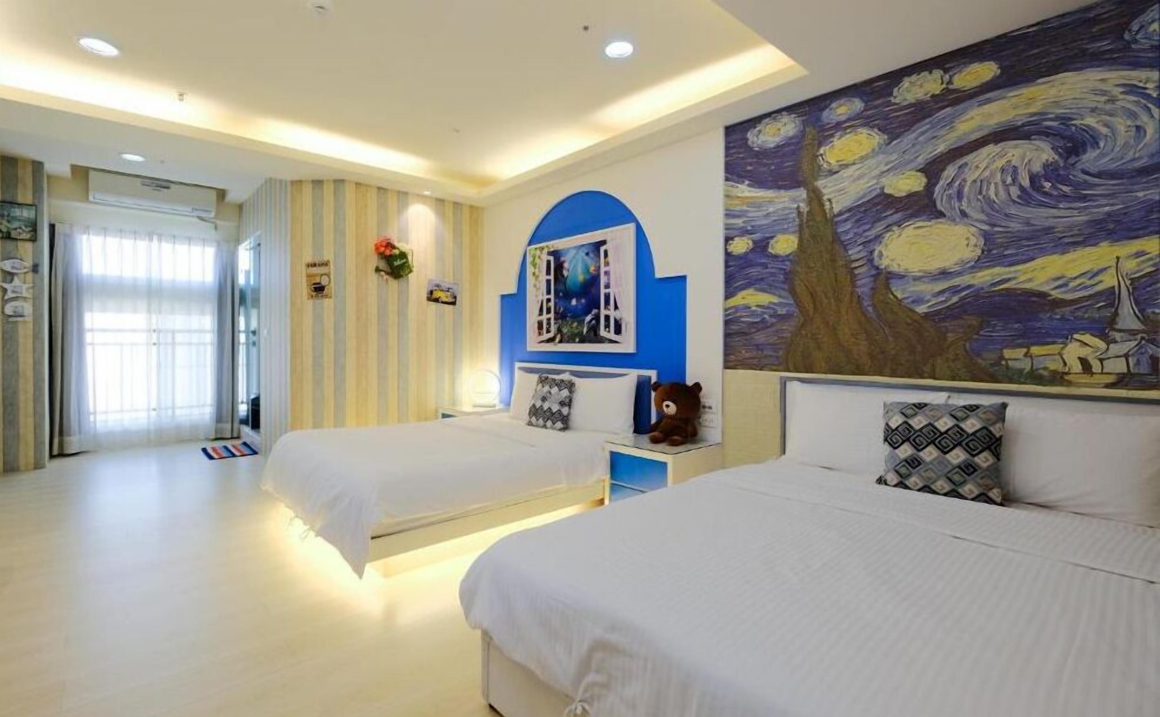 A hotel room with two beds, a large painting on the wall, and a window with curtains.