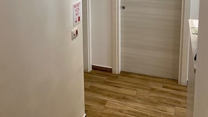 A hallway with a door labeled "R.U." and another door with "B&B" signage. A security camera is mounted on the wall, and a reset SOS WC sign is visible. - BeB Caruso (Sorrento)