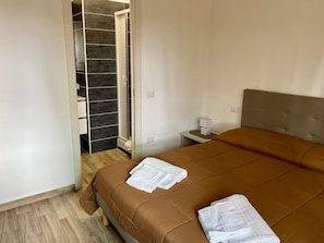 A bedroom with a bed, a nightstand, a lamp, and a closet with a mirror. - BeB Caruso (Sorrento)