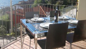 A dining table set for two with a view of a mountainous landscape.