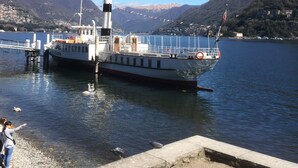 A boat docked at a pier with a mountainous backdrop.