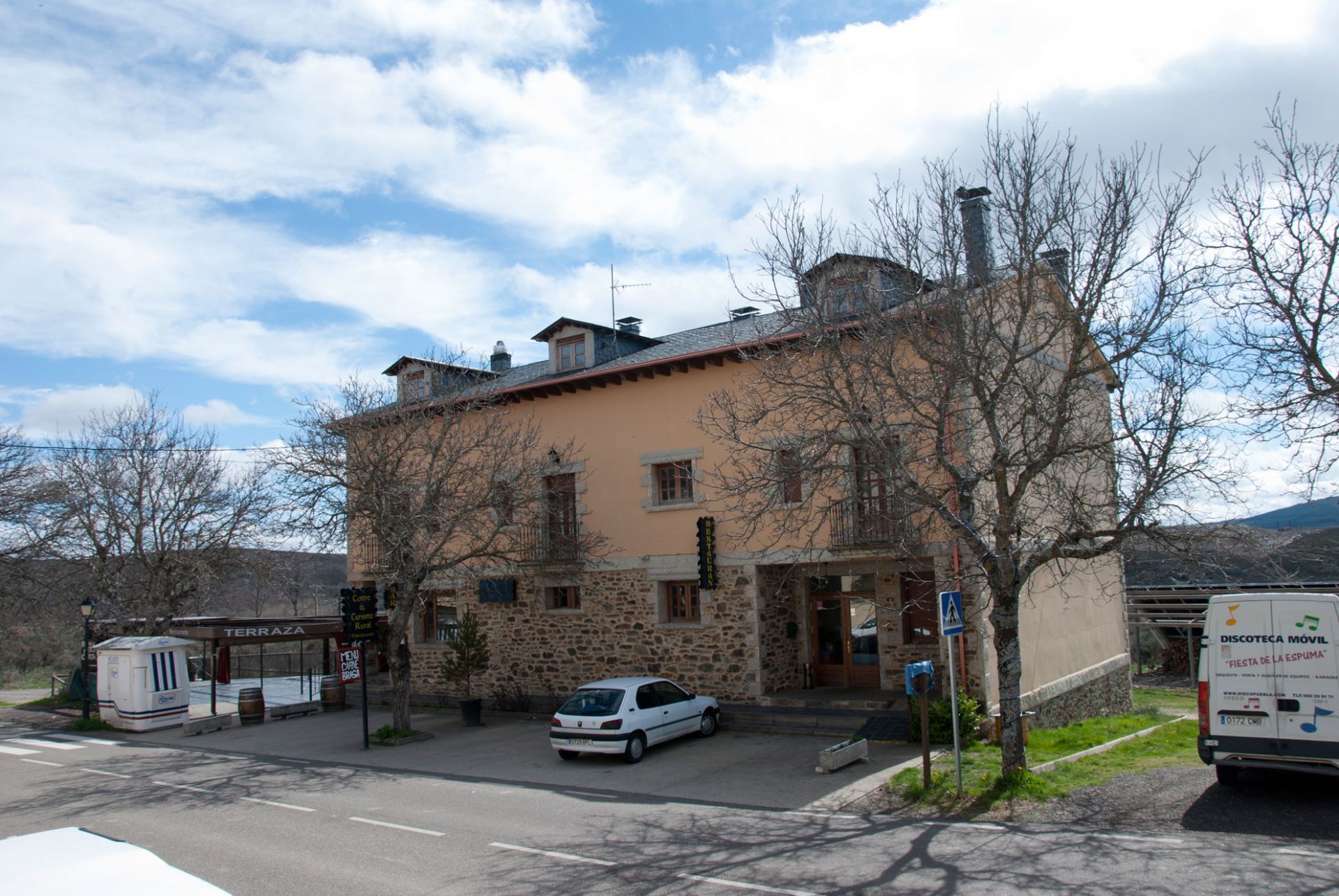 A stone building with a flat roof and a car parked in front.