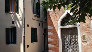 A narrow street with buildings on either side, featuring a mix of modern and traditional architecture.