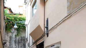 A narrow alleyway with a building on one side, a door, and a window.