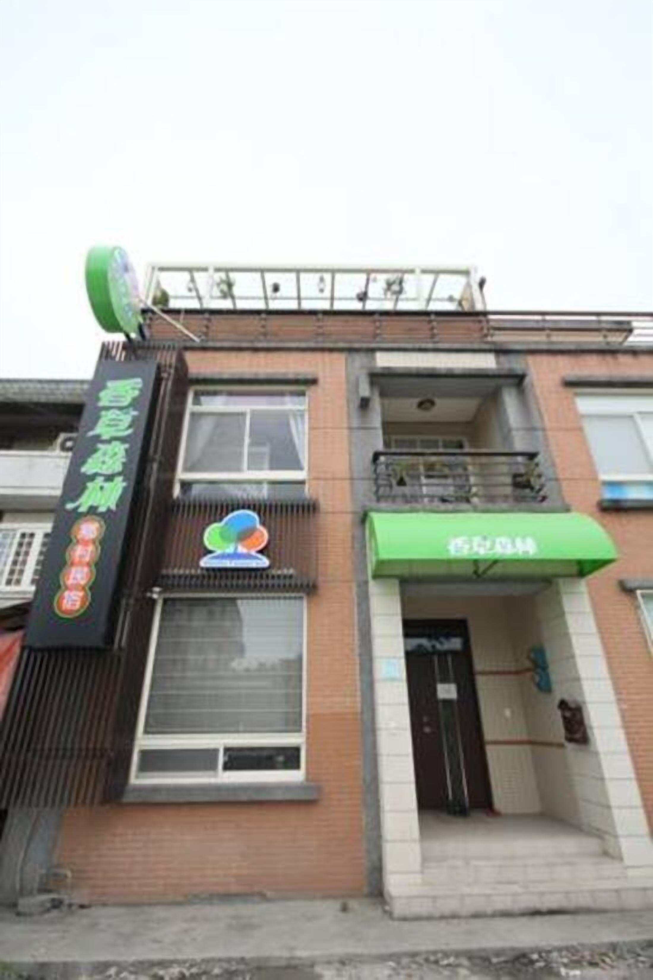 A building with a green awning and a sign with Chinese characters.