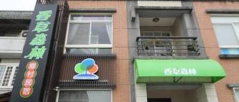 A building with a green awning and a sign with Chinese characters.
