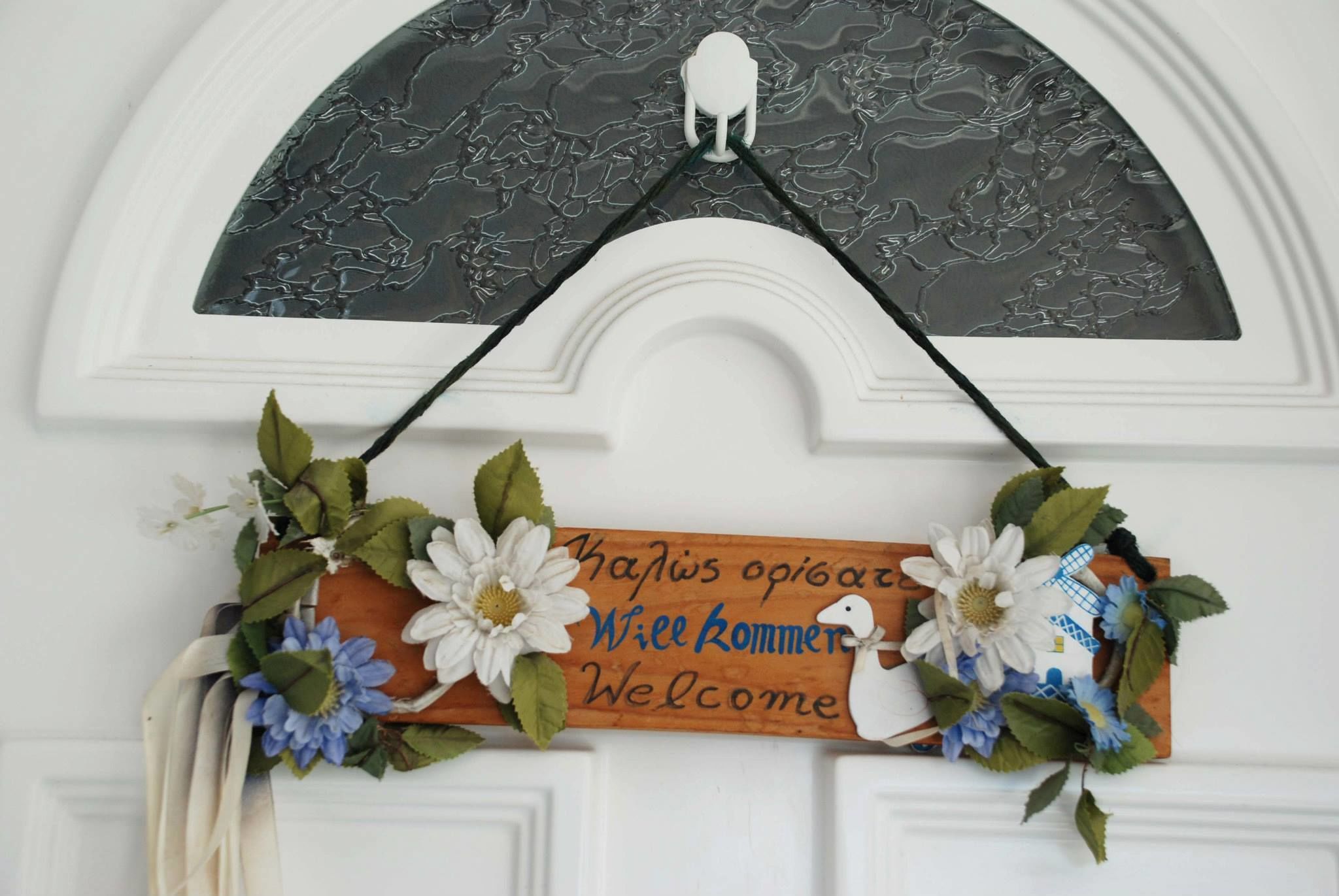Un cartell de benvinguda amb un ventilador i flors.