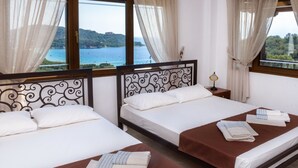 A hotel room with two beds, a view of the sea, and a balcony. - Demi Studios (Aristotelis)