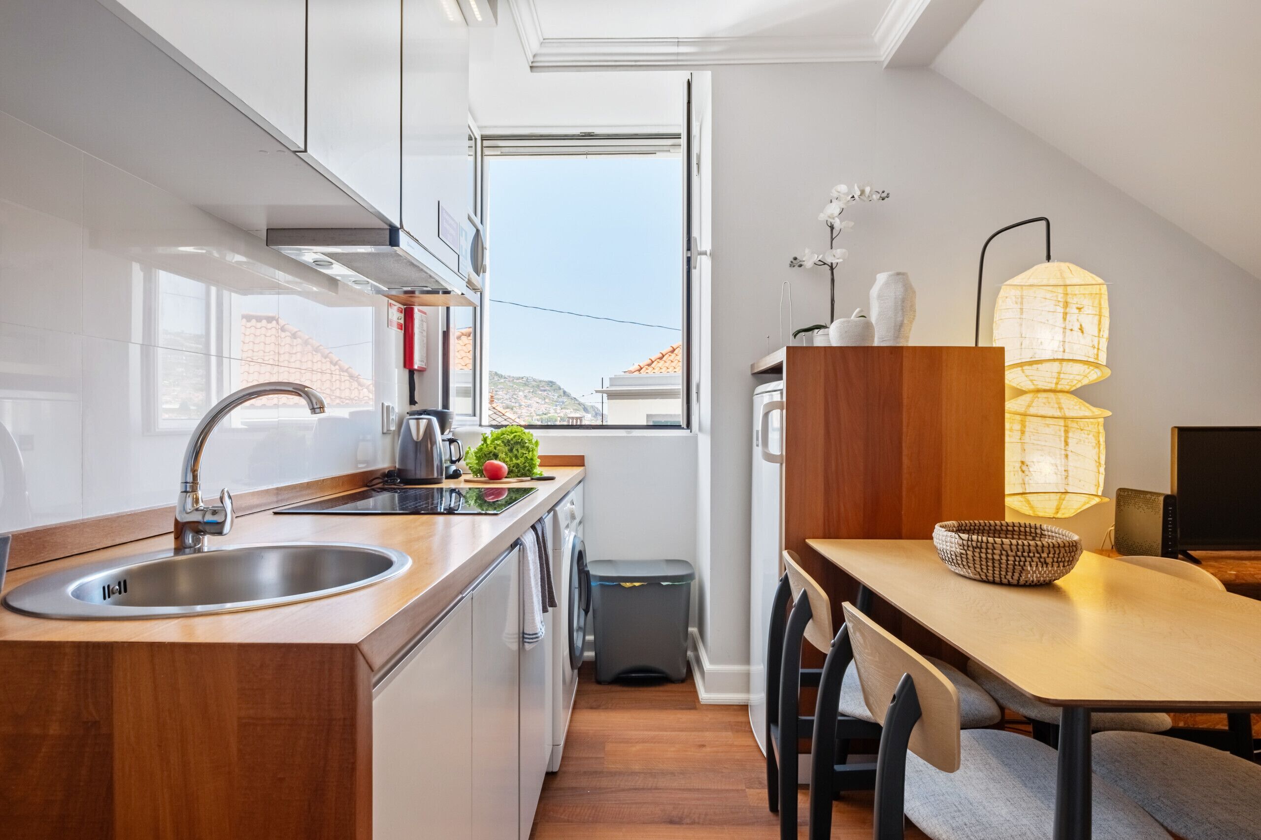 A modern kitchen with a sink, stove, and dining area.