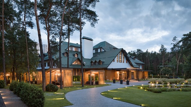 A large, modern hotel with a spacious outdoor area, including a paved walkway and well-maintained lawn. - Onovo (Kyiv)