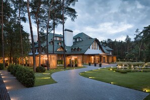 A large, modern hotel with a spacious outdoor area, including a paved walkway and well-maintained lawn. - Onovo (Kyiv)
