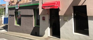 A building with a red awning labeled "Hotel" and a sign for "PMUS." - Hôtel du Commerce (Les Sables-d'Olonne)