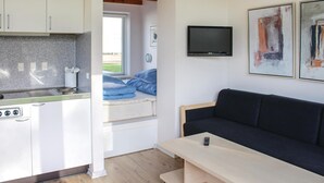 A compact living space with a kitchenette, a sofa, a TV, and artwork on the wall. - Nice studio in Løgumkloster with WiFi (Løgumkloster)