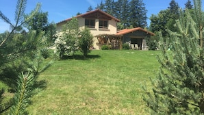 A house with a stone exterior, a red roof, and a well-maintained lawn. - Alcove du Velay (Polignac)