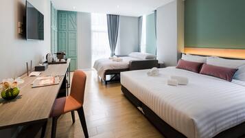 A modern hotel room with a large bed, a desk with a chair, a television, and a window with curtains.