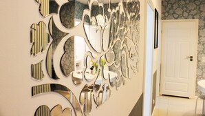 Eine Wand mit dekorativer Spiegelanordnung in einem Flur.