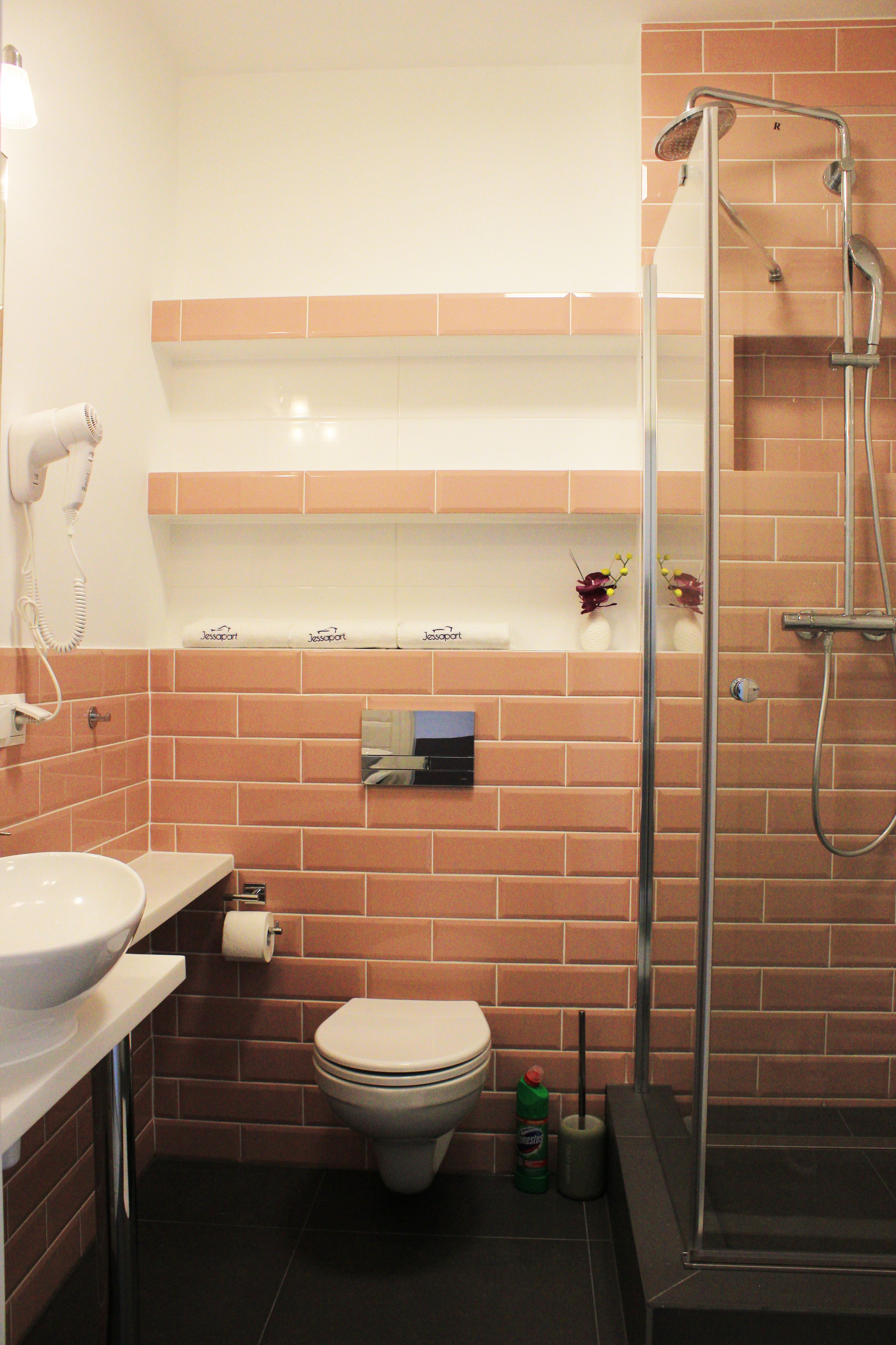 A bathroom with a toilet, sink, and shower.