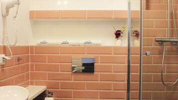 A bathroom with a toilet, sink, and shower.