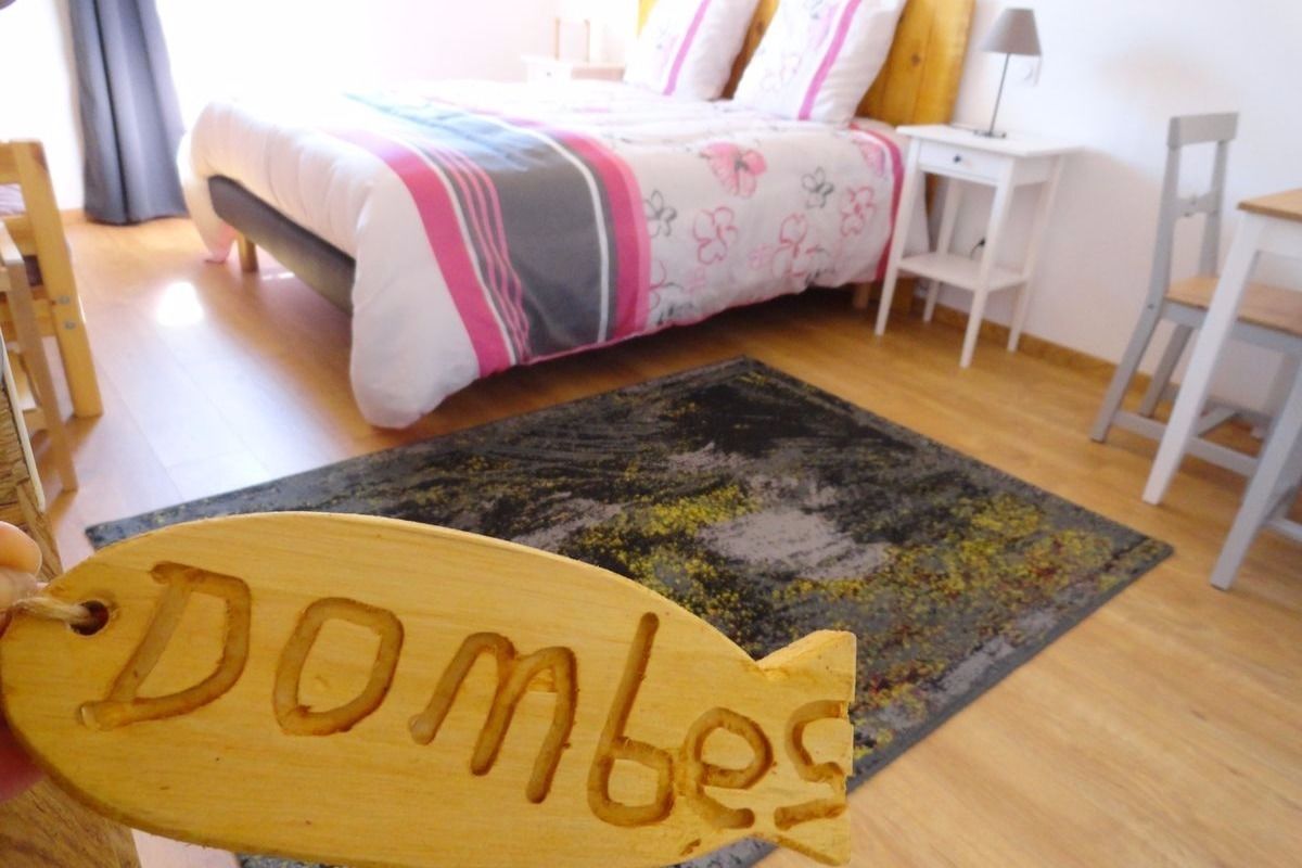 Un dormitorio con una cama, una mesita de noche, una silla y una alfombra.