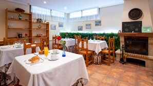 Un comedor con mesas, sillas y una chimenea.