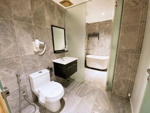 Une salle de bain moderne équipée de toilettes, d’un lavabo et d’une baignoire.