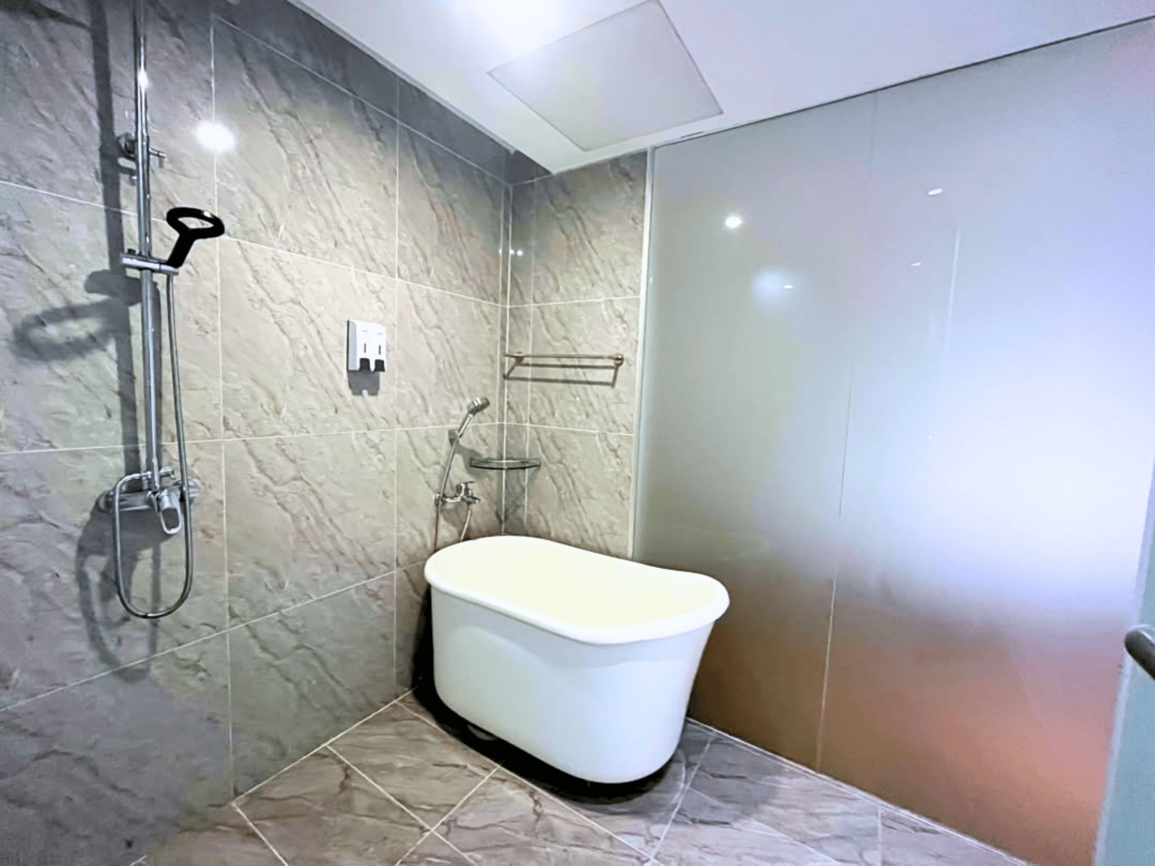 A bathroom with a shower, a toilet, and a sink.