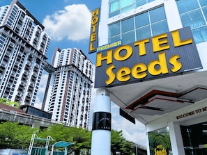 Une enseigne d’hôtel portant le nom « Hotel Seeds » et le mot « Premier » au-dessus.