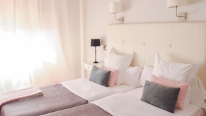 Une chambre d’hôtel avec deux lits, une table de chevet et une lampe.