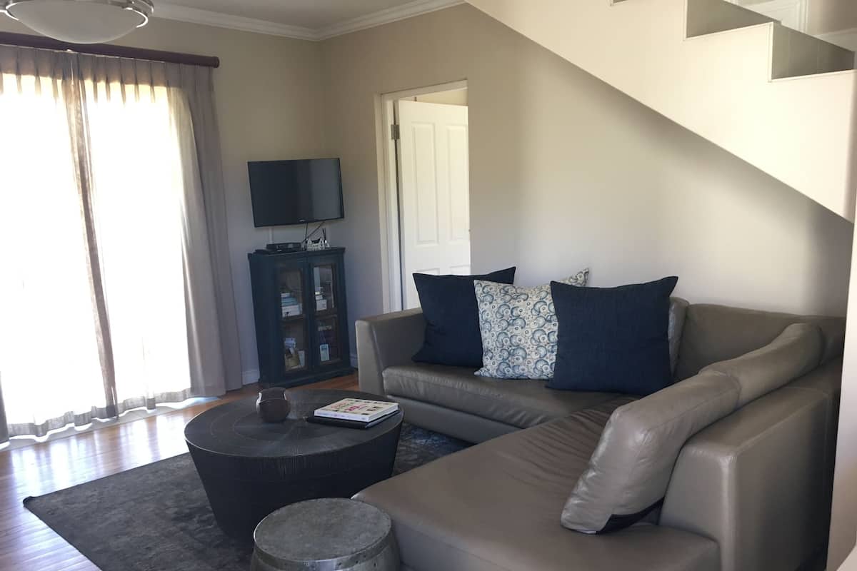 A living room with a sofa, a coffee table, a cabinet, and a television.