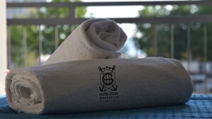 A rolled white towel with a logo and text indicating it is from Hotel Goya Marebello Rimini. - Hotel Goya (Rimini)