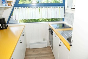 Kjøleskap, ovn, oppvaskmaskin og høy barnestol