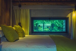 A bedroom with a bed, yellow pillows, a window with a view of greenery, and a wooden ceiling. - Xihu Memories Tree Hotel (Hangzhou)