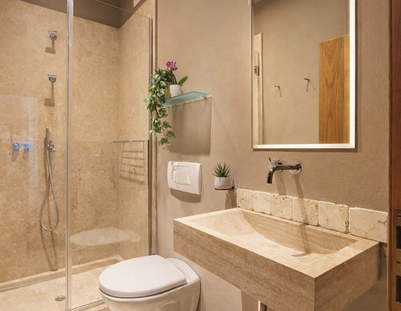 A modern bathroom with a glass-enclosed shower, a large sink, and a toilet.