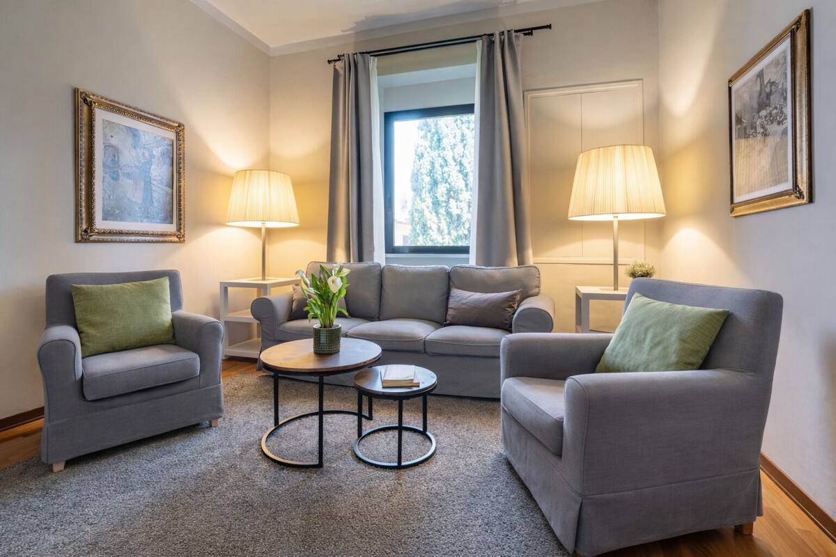 A modern living room with grey sofas, green cushions, a coffee table, and two lamps.