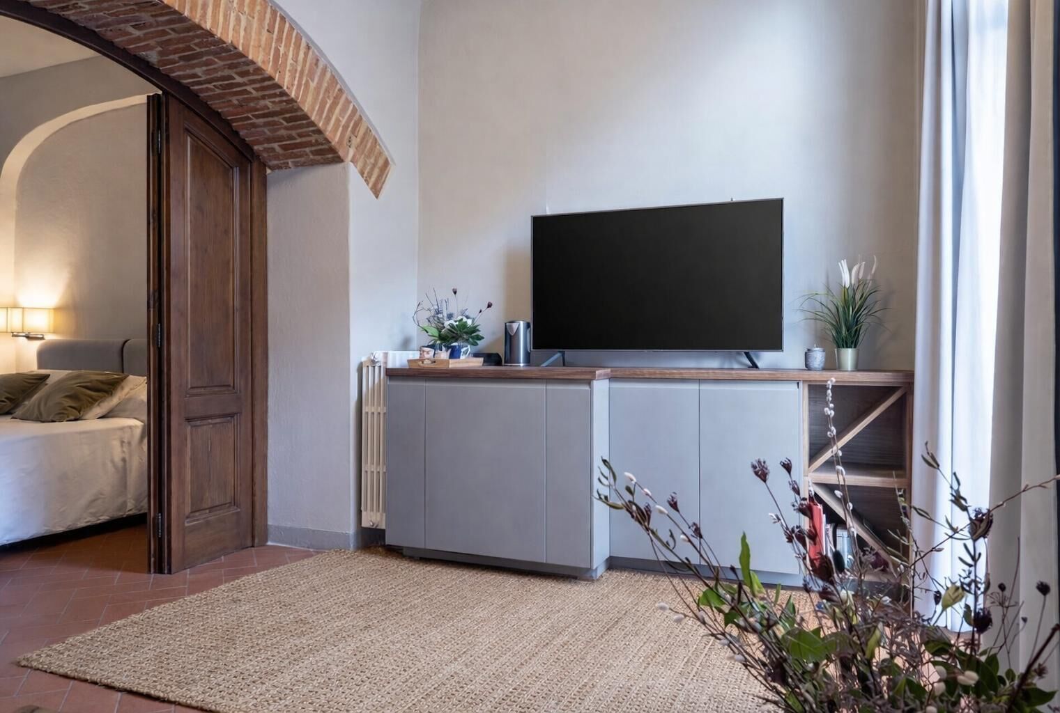 A modern living room with a flat-screen TV, a sofa, and a coffee table.