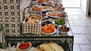 Ein Buffet mit verschiedenen Speisen und einer Wand mit geometrischem Muster aus Fliesen.