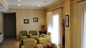 A spacious living room with four armchairs, a small table, and a decorative vase with flowers. - Rey Teodomiro (Orihuela)