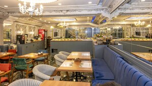 Een restaurant met marmeren vloeren, zachte zitplaatsen en een bar met een Coca-Cola bord.